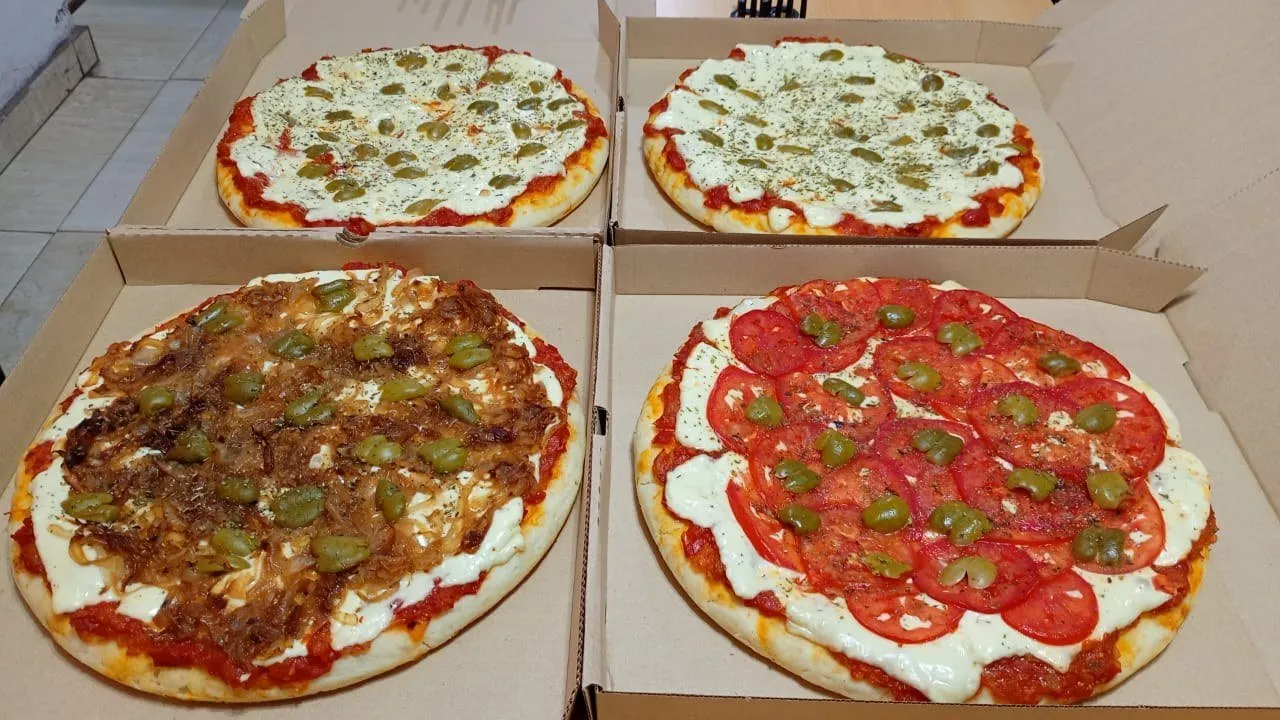 Cuatro pizzas de El Balconcito recién hechas en sus cajas